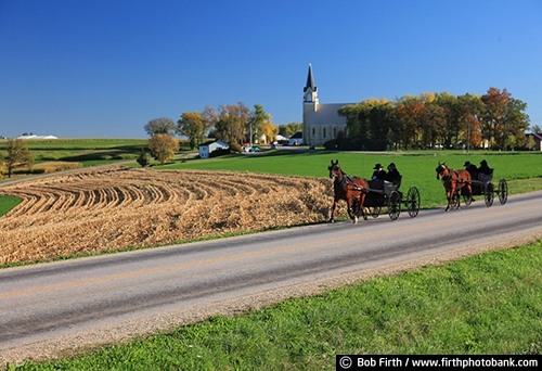 agricultural scene;agriculture;Amish;blue sky;carriage;church;country;crop;couple;fall;farm;field;horse drawn carriage;man;road;wagon;WI;Wisconsin;woman