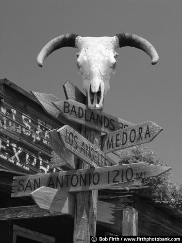 hand painted;mural;wall art;southwest;southwestern;adobe;Indian;woman;painting on adobe;black and white photo;South Dakota;1880 Ghost Town;Americana;destination;SD;sign;informational sign;skull;signage;tourism;cow skull;directional sign