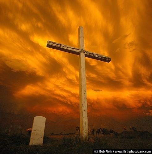 cemetery;cross;country;inspirational;religious;sunset;symbolic;symbolism;storm clouds;South Dakota;SD;powerful;ominous sky;grave marker;grave stone;dramatic light;orange sky