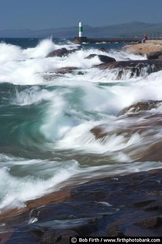 swirling waves;teenager;person sitting on rock;person contemplating;waves;shoreline;Sawtooth Mountains;rocky shore;photo;northern Minnesota;North Shore towns;North Shore Scenic Drive;North Shore lighthouses;North Shore;moving water;Minnesotas North Shore;Minnesota;lighthouse;Lake Superior;Grand Marais Lighthouse;Grand Marais;biggest fresh water lake;Great Lakes;MN