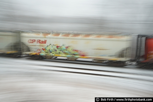 Railroad;industry;train;train cars;transportation;winter;snow on train tracks;snowy tracks;snowy;snow;train in motion;motion;blur;Wisconsin;WI;railcars;graffiti