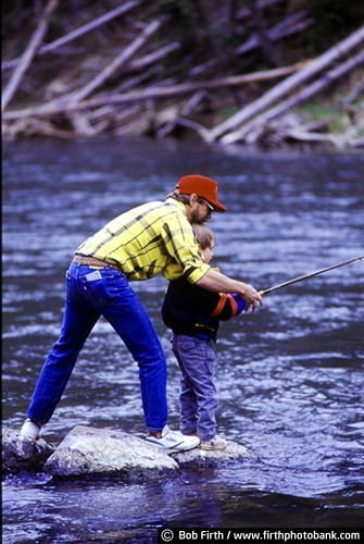 Fishing;child;boy;male;companionship;togetherness;family activity;generations;father and son;dad and son;fishing pole;fishing rod;rod;fly fishing;fun pastime;Idaho;Henrys Fork of the Snake River;ID;man;peaceful;recreation;river;standing on rocks;fishing from rocks;fly rod