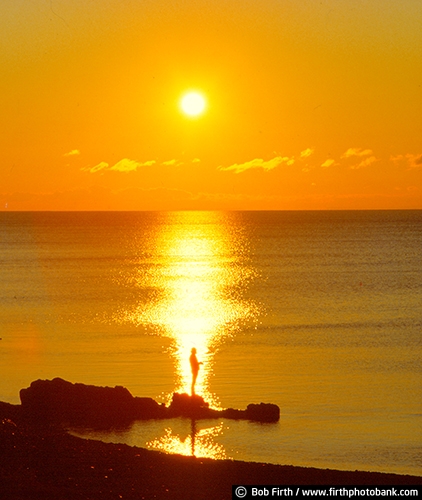 Lake Superior;Kitchi Gammi;largest freshwater lake;Minnesotas North Shore;MN;northern Minnesota;peaceful;shoreline;tourism;water;destination;biggest fresh water lake;calm water;dramatic sky;fishing;Duluth;Great Lakes;luminated;man standing on rock;moody;people;silhouettes;silhouette of fisherman;sun;sunset;yellow sky