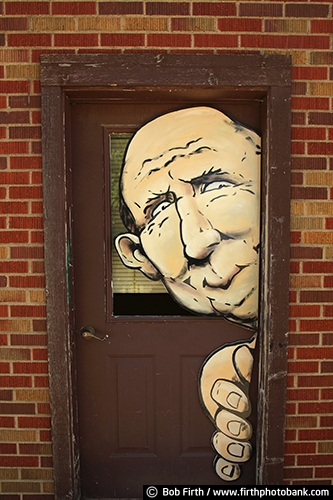 man;door;brick wall;building;comical;face;funny;hand;people;signage;signs;fingers;humoruous;humor
